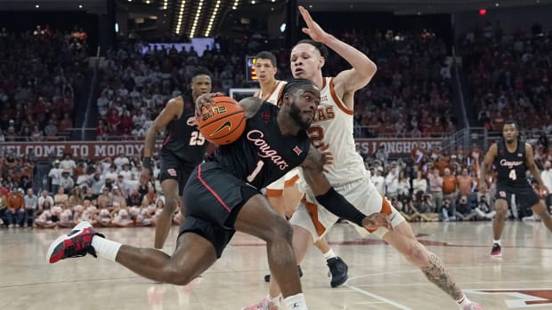 Houston Cougars guard Jamal Shead (1) drives to the basket while defended by Texas Longhorns guard Chendall Weaver (2) during the second half at Moody Center. 